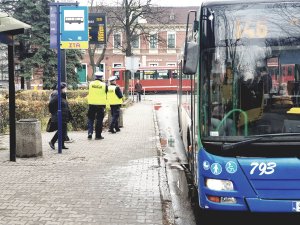 policjanci kontrolują obowiązek zakrywania ust i nosa w autobusach - na zdjęciu autobus, przystanek, policjanci