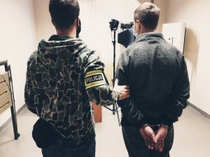 policjant i zatrzymany pedofil w pomieszczeniu do daktyloskopii i identyfikacji