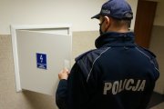 policjant na korytarzu przy skrzynce elektrycznej