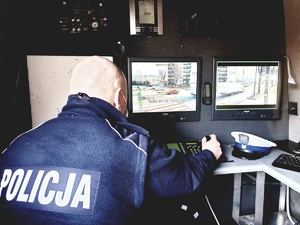 policjant wewnątrz samochodu z kamerami, przed nim monitory z widokiem na ulicę i przejście dla pieszych