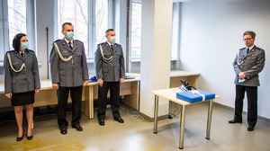 zdjęcie z uroczystości pożegnania - sala odpraw, policjantka, dwóch policjantów i przemawiający odchodzący na emeryturę komendant