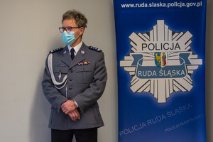 zdjęcie z uroczystości pożegnania - sala odpraw, odchodzący komendant, obok baner rudzkiej policji