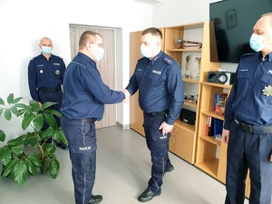 gabinet komendanta po lewej stoi zastępca komendanta miejskiego, na środku dwóch awansowanych policjantów, komendant składa gratulacje