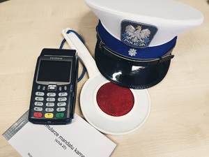 czapka policjanta z drogówki, tarcza do zatrzymywania pojazdów, bloczek mandatowy i terminal płatniczy