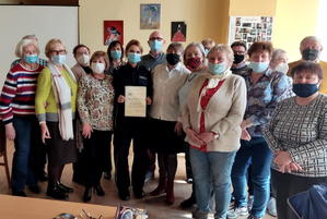 zdjęcie grupowe, seniorzy wraz z komendant komisariatu