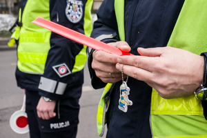 policjanci z drogówki , jeden trzyma odblaski, które mają być rozdawane pieszym