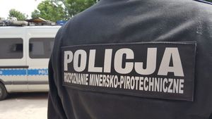 policyjny pirotechnik tyłem w tle policyjny radiowóz