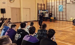 Policjant prowadzący prelekcje dla uczniów w auli Szkoły
