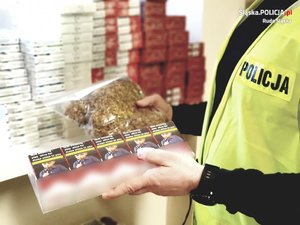 Policjant trzymający nielegalne papierosy i tytoń