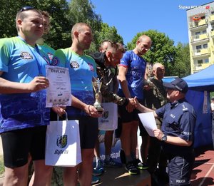 podium na którym stoją zawodnicy tworzący drużyny, moment dekoracji