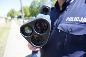 policjant trzymający w rękach radarowy miernik prędkości