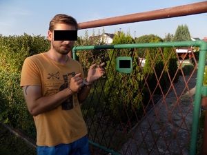 zatrzymany sprawca, pokazujący na działkę, gdzie dokonał włamania