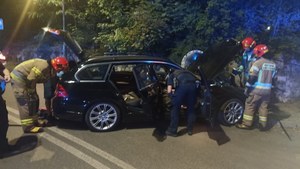 rozbite bmw, przy samochodzie policjanci i strażacy