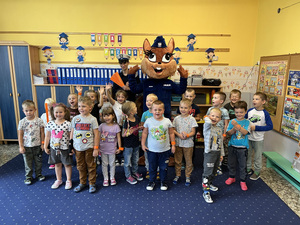 sala przedszkolna, dzieci wraz z policjantem i maskotką policji pozują do wspólnego zdjęcia