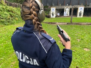 zajęcia strzeleckie na strzelnicy otwartej, policjantka w mundurze stoi z bronią po strzale