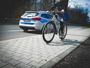 radiowóz na drodze, na ścieżce rowerowej rowerzysta - zdjęcie poglądowe z archiwum