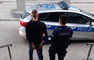 policjant z zatrzymanym przy radiowozie oznakowanym
