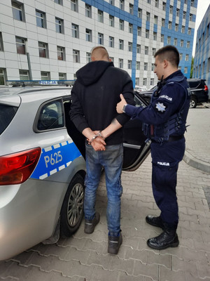 policjant z zatrzymanym przy radiowozie oznakowanym