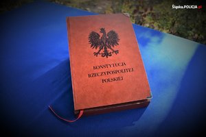 stolik z niebieskim nakryciem i na środku konstytucja