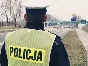 policjant z drogówki, w tle droga, ścieżka rowerowa i wiadukt