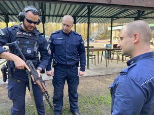 strzelnica otwarta - instruktor przypomina zasady bezpieczeństwa przy używaniu karabinu, obok stoi dwóch policjantów