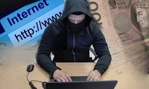 zdjęcie poglądowe przedstawia mężczyznę w kapturze przy komputerze, obok pieniądze