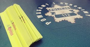 zdjęcie, na masce policyjnego radiowozu leżą odblaskowe opaski z logiem radia express