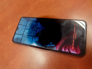 zdjęcie - telefon koloru ciemnoszarego leży na blacie biurka