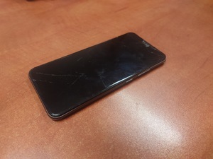 zdjęcie - telefon koloru ciemnoszarego leży na blacie biurka