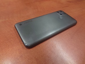 zdjęcie - telefon koloru ciemnoszarego leży na blacie biurka