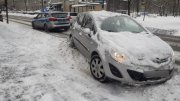 zdjęcie poglądowe - zaśnieżone auto, obok stojący radiowóz policyjny