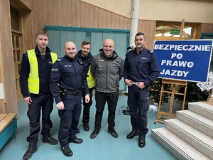 zdjęcie przedstawia czterech policjantów i kierowcę rajdowego Jarka Szeja pozujących do zdjęcia