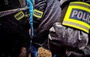 zdjęcie poglądowe, osoby przy samochodzie na rękach mają opaski z napisem policja