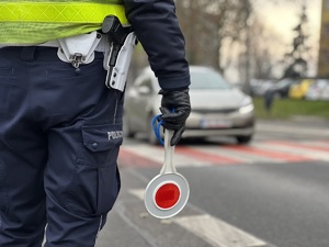 zdjęcie przedstawia policjanta drogówki przy przejściu dla pieszych z tyłu widać samochód