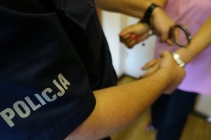 zdjęcie poglądowe - policjant zakłada kajdanki kobiecie