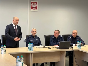 zdjęcie przedstawia siedzących przy stole zaproszonych gości i komendantów, prezydent miasta stoi i przemawia