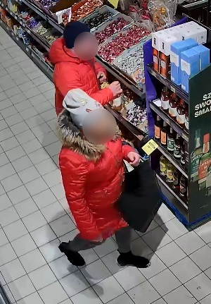 zdjęcie z monitoringu przedstawia kobietę i mężczyznę pomiędzy sklepowymi półkami, mają zanonimizowane wizerunki