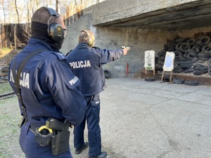 zdjęcie z treningu strzeleckiego - instruktor strzelectwa nadzoruje trening policjanta
