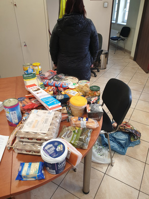 zdjęcie - na stole wystawione skradzione produkty i kobieta stojąca obok tyłem