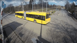 zdjęcie z monitoringu przedstawiające żółty autobus miejski wjeżdżający na przejazd kolejowy gdy zapory zamykały się - zdjęcie z kanału youtube Business Control Monitoring