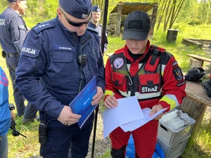 zdjęcie - policjant i strażak omawiają założenie ćwiczeń