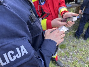 zdjęcie - policjant i strażak z telefonami w rękach konfigurują aplikację siron