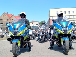 zdjęcie - dwaj policjanci na służbowych motocyklach, za nimi kolejni motocykliści uczestniczący w paradzie
