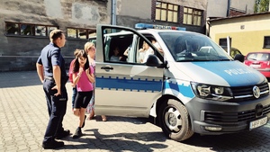 zdjęcie - dzieci i policjant przy radiowozie na placu przy szkole