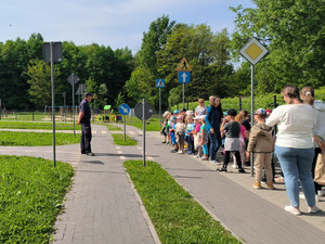 zdjęcie - dzieci z przedszkola wraz z dzielnicowym w miasteczku ruchu drogowego