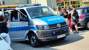 Policyjny radiowóz, a w nim uczniowie