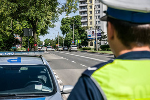 zdjęcie poglądowe - policjant przy radiowozie