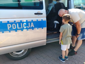 Mieszkańcy oglądający policyjny radiowóz