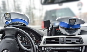 zdjęcie przedstawia wnętrze policyjnego radiowozu i czapki policjantów z drogówki
