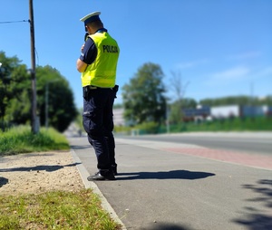 policjant z drogówki w trakcie pomiaru prędkości